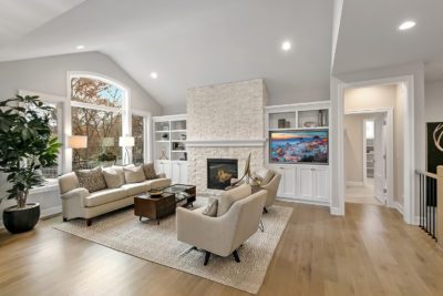 Luxury living room with fireplace, large wall of windows, and built-in shelving.