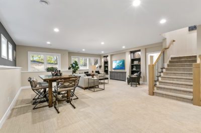 Lower level with carpeting, built-in shelves, generous space, and windows with plenty of light.